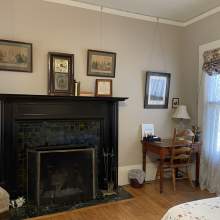President's Room view of wood-burning fireplace. writing desk and east facing window
